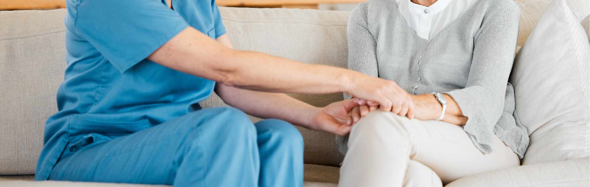 Eine Intensivpflegerin der außerklinischen Intensivpflege Unique nimmt die Hände der Tochter eines Patienten